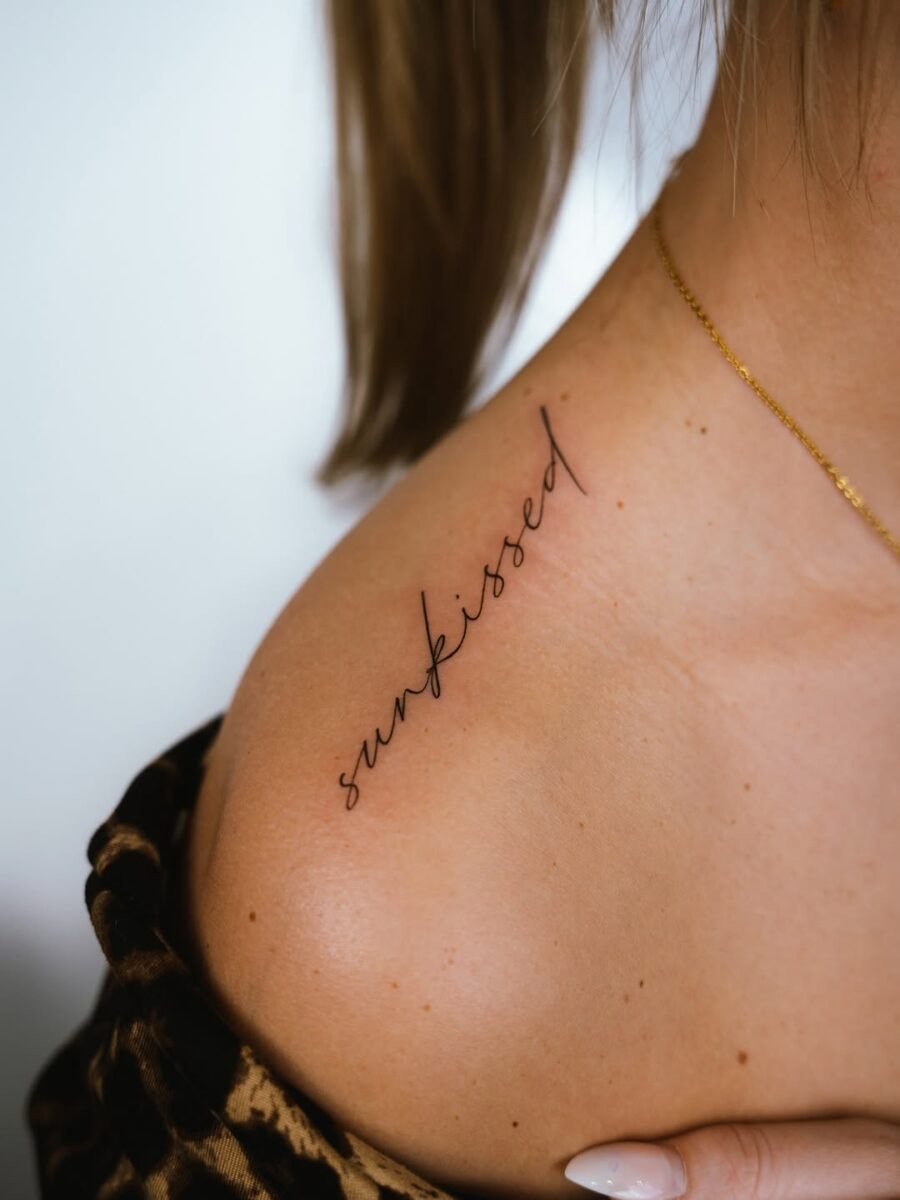 Sleek and elegant script tattoo on shoulder Tattoo Design