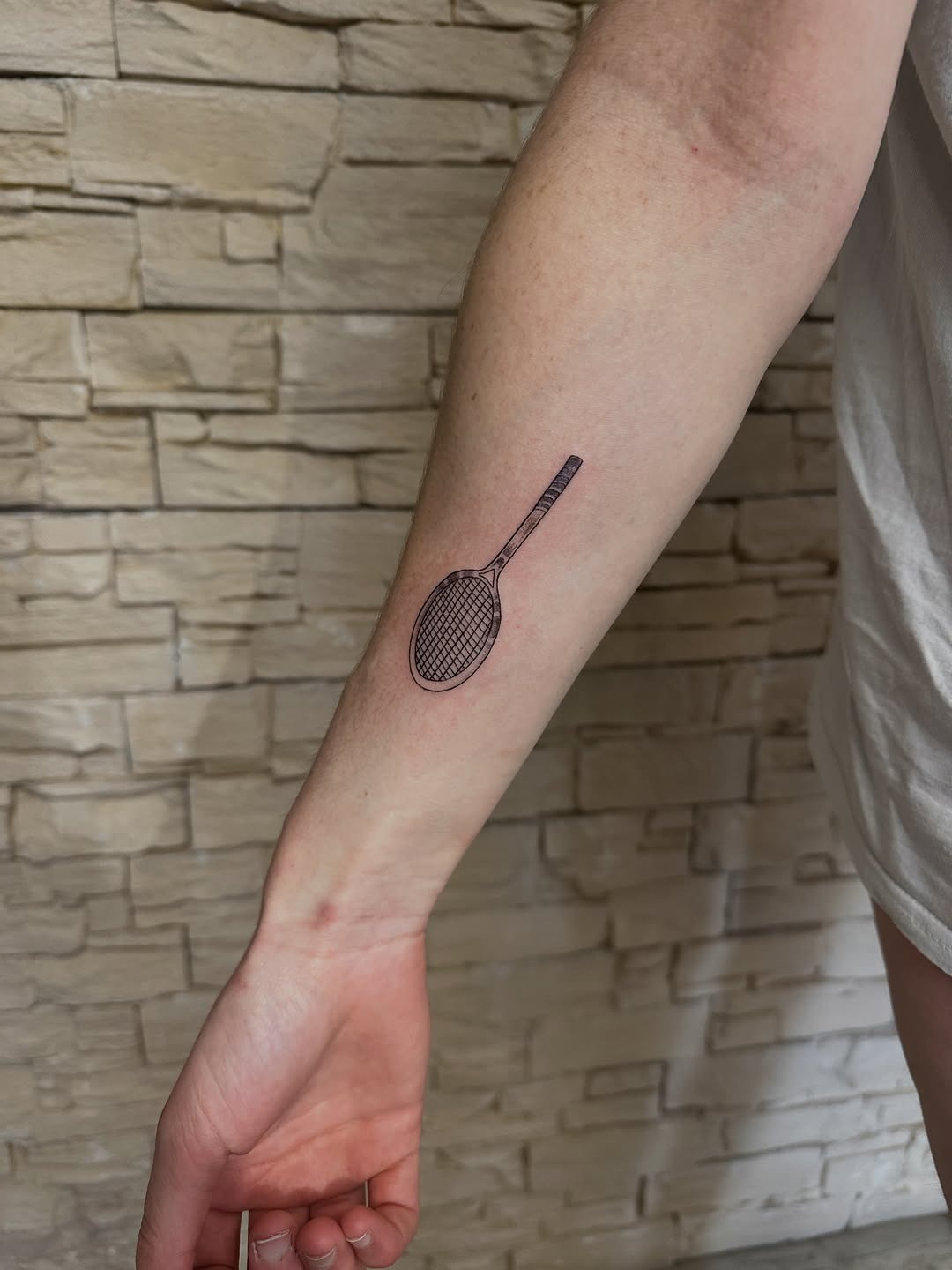 Minimalist tennis racket tattoo on forearm Tattoo Design