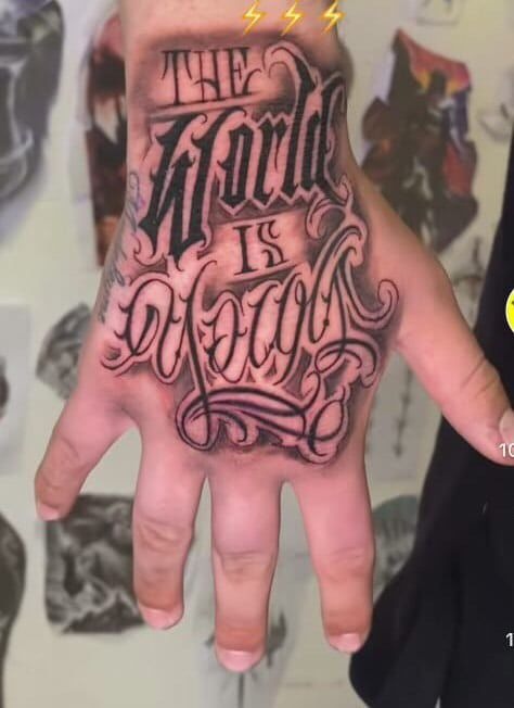 Oversized Gothic Script on Hand Tattoo Design
