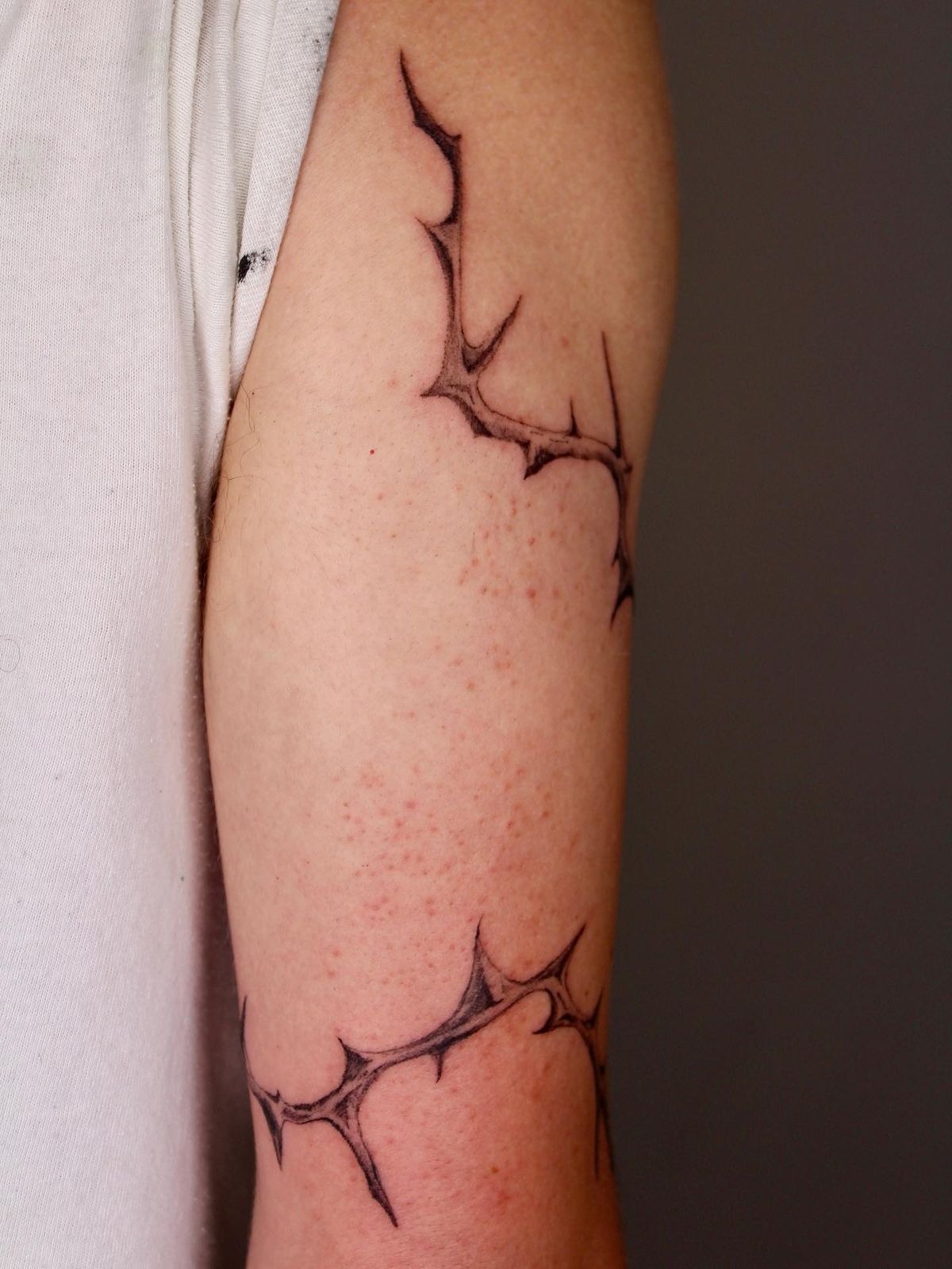 Fine-Line Thorn Armband With Barely-There Bite, a tattoo design rendered in clean detailed linework.