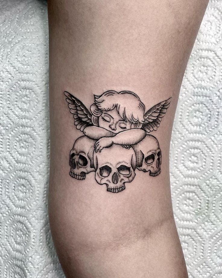 Cherub Resting on Three Skulls Tattoo Design