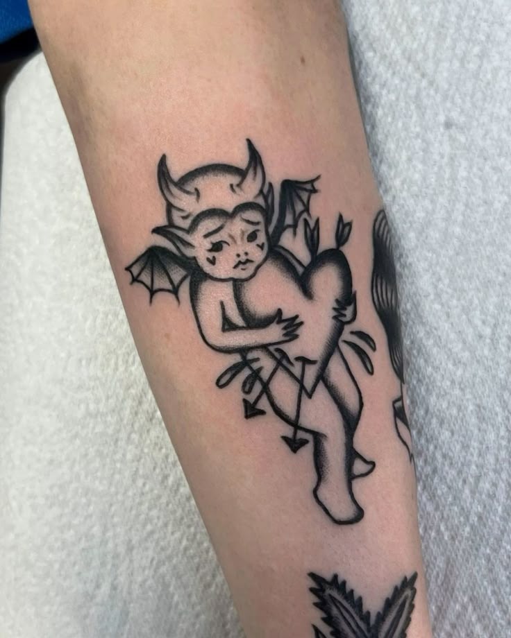 Little Devil Cherub Hugging a Heart Tattoo Design