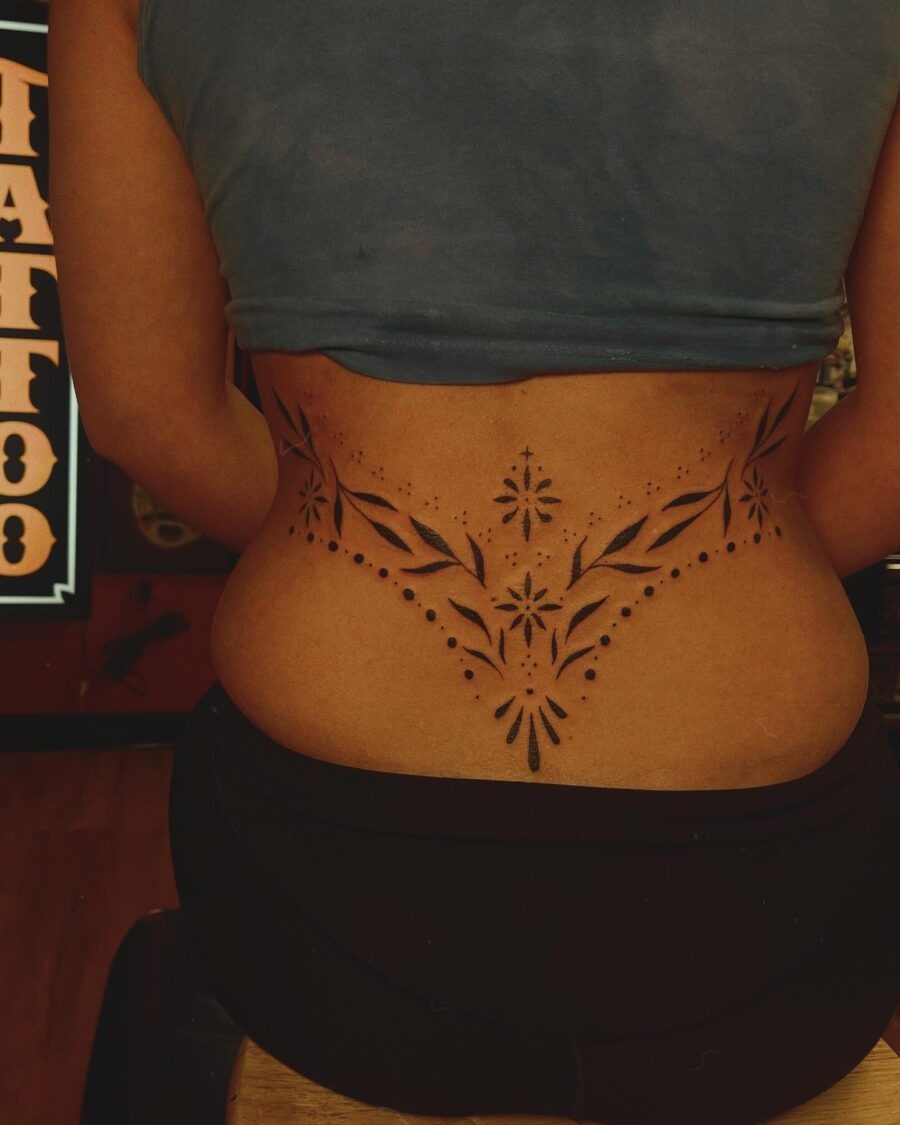 Intricate floral tramp stamp tattoo in black ink Tattoo Design