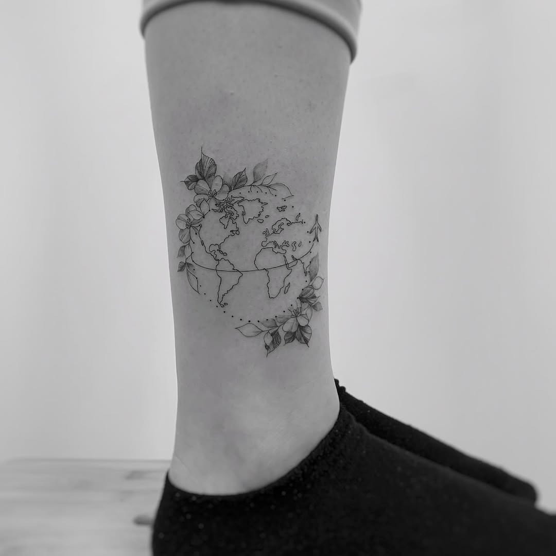 Elegant globe tattoo with floral accents Tattoo Design
