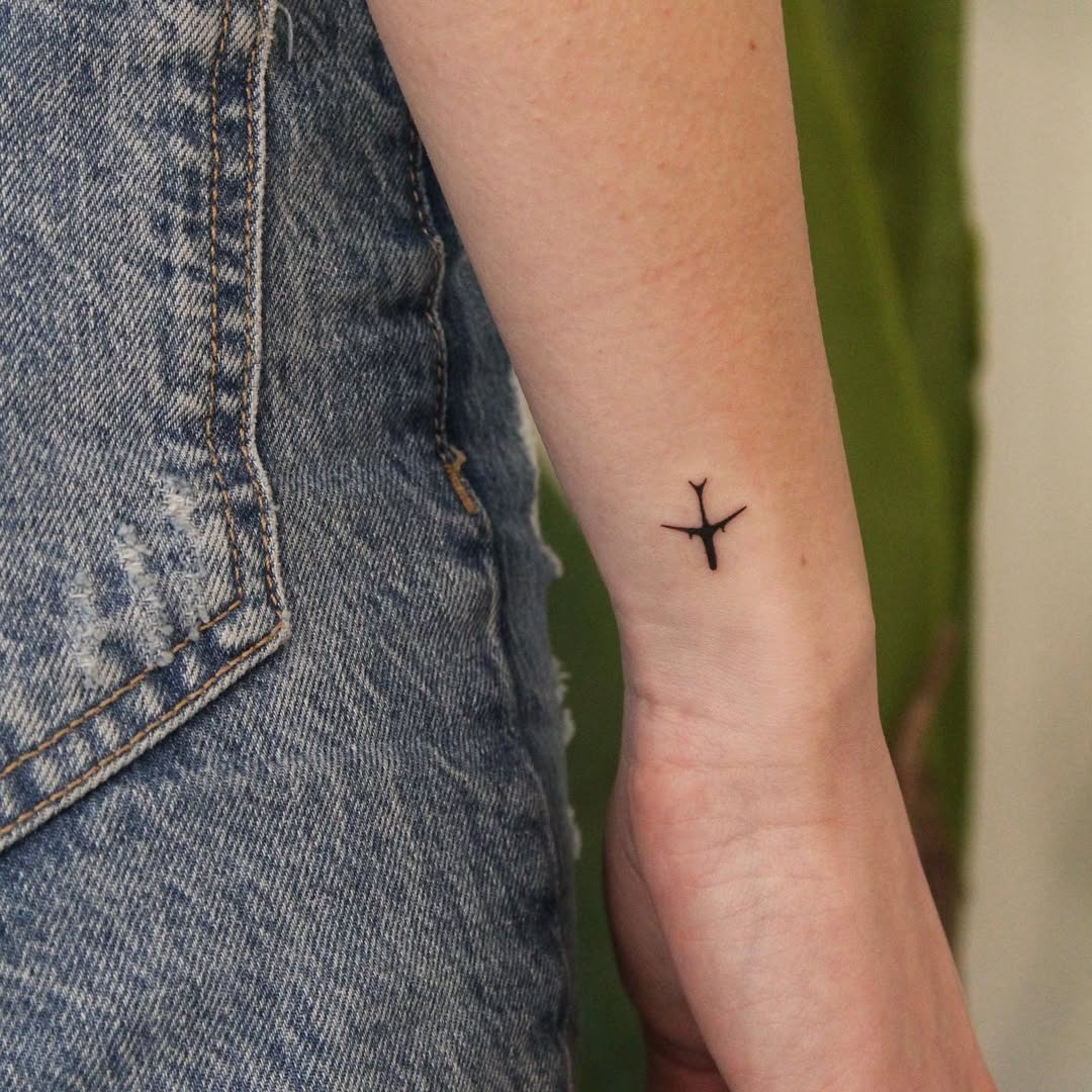 Minimalist airplane tattoo on the arm Tattoo Design