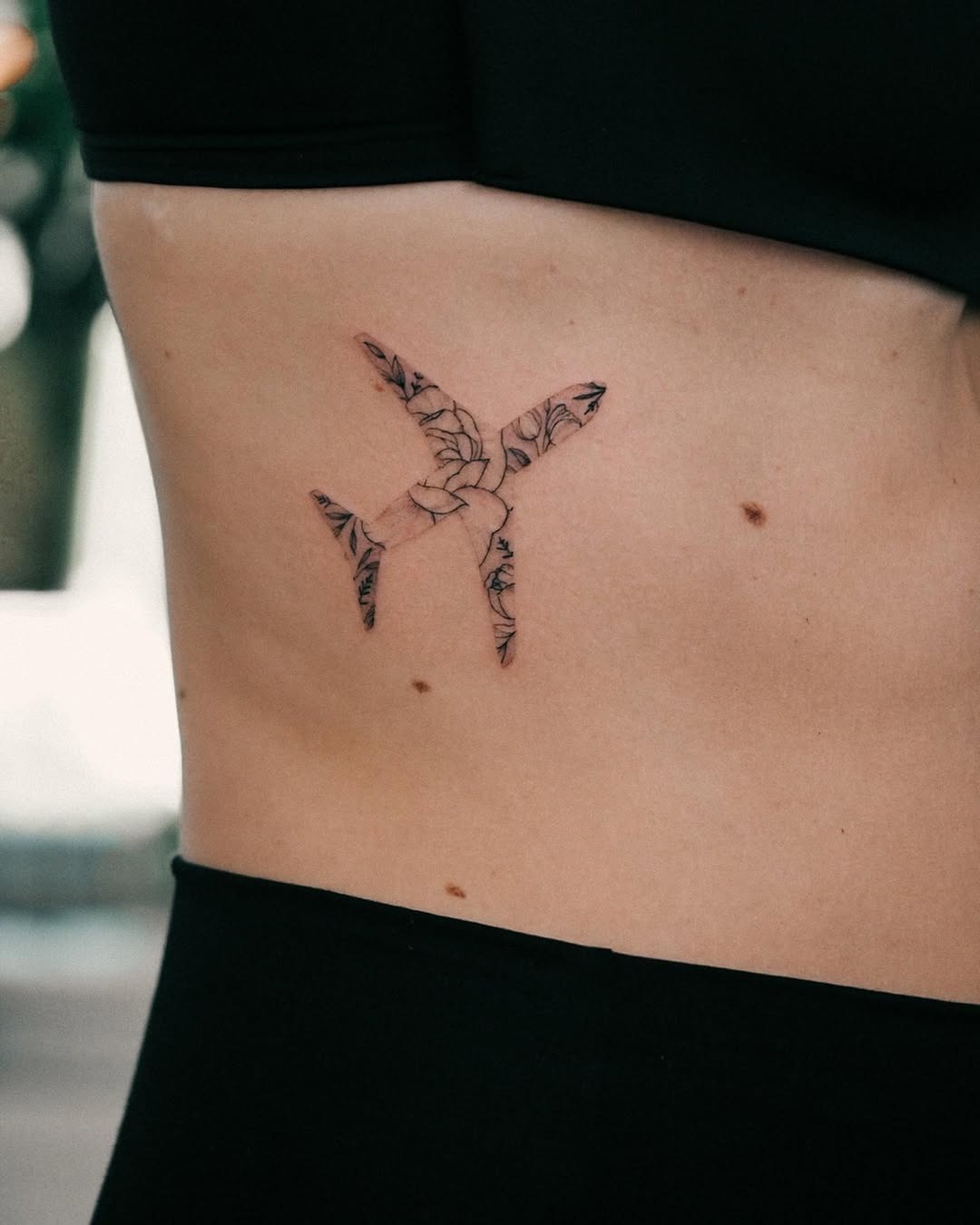 Stylish airplane tattoo with floral details Tattoo Design