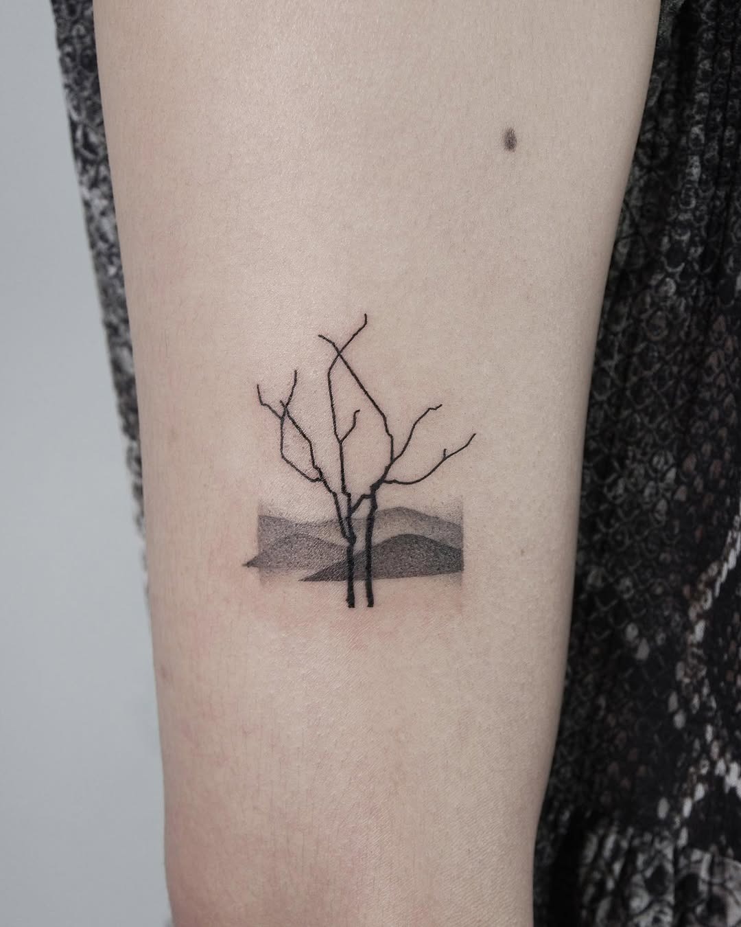 Minimalist tree tattoo with a serene landscape Tattoo Design
