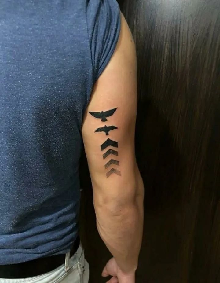 Men’s Minimalist Chevron + Birds Tricep Tattoo, a tattoo design rendered in minimalist fine-line.