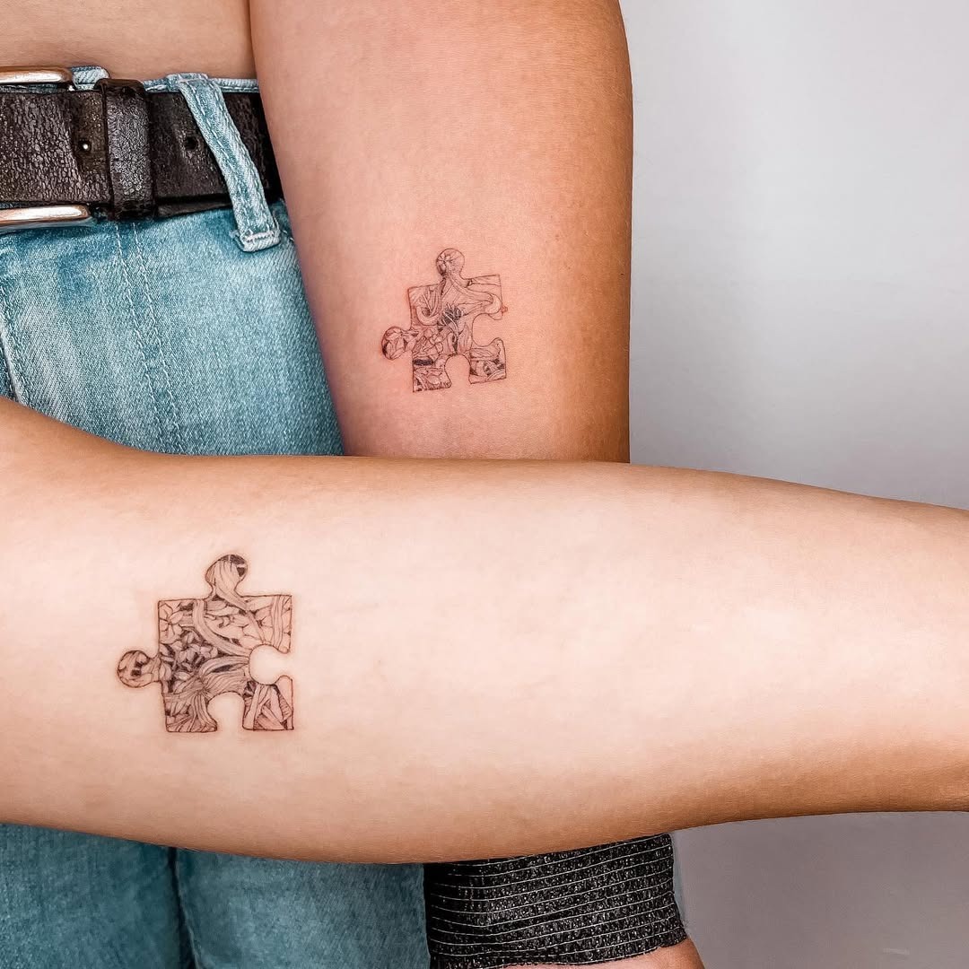 Interlocking puzzle piece twin tattoos highlight connection Tattoo Design