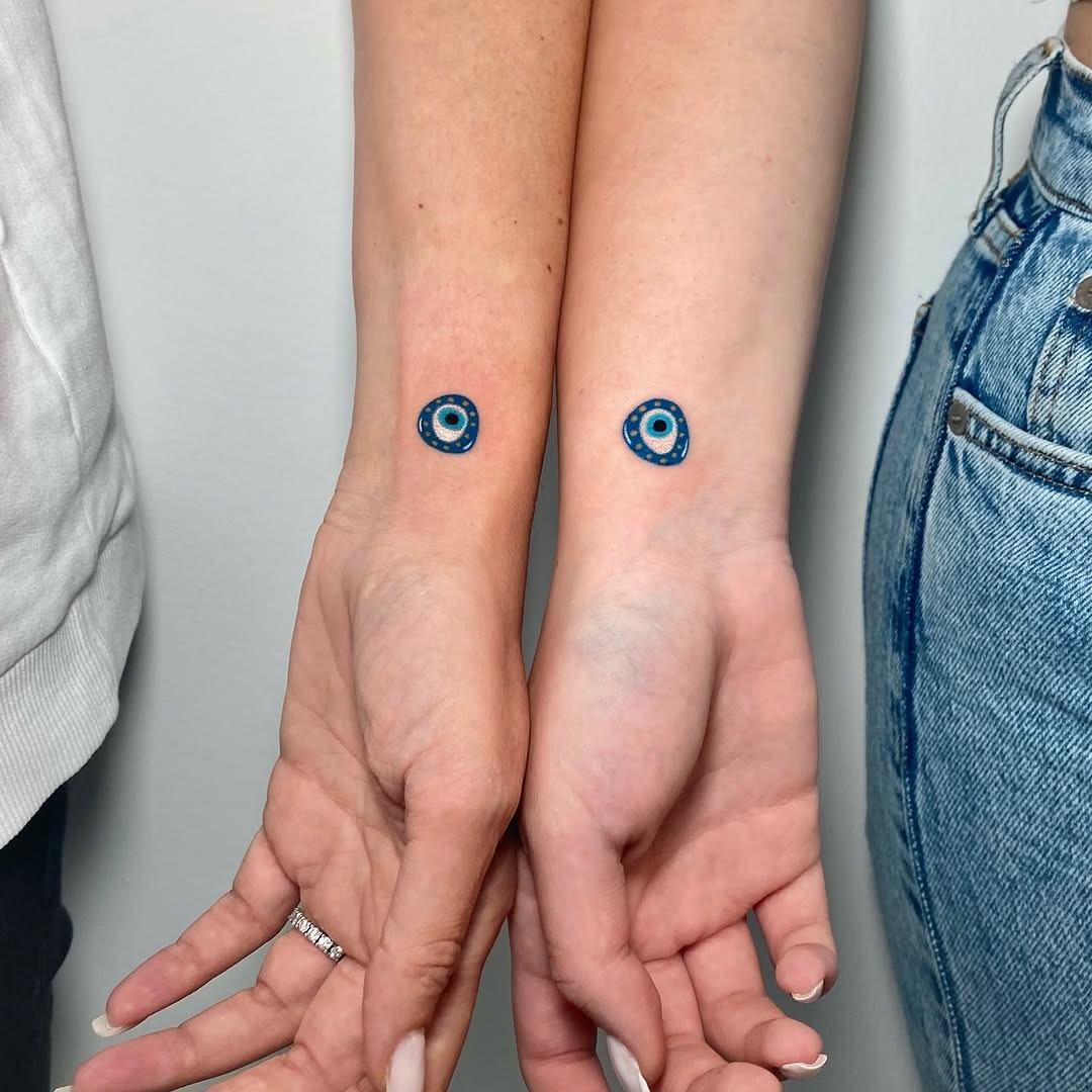 Stylish twin tattoos with blue circle design Tattoo Design