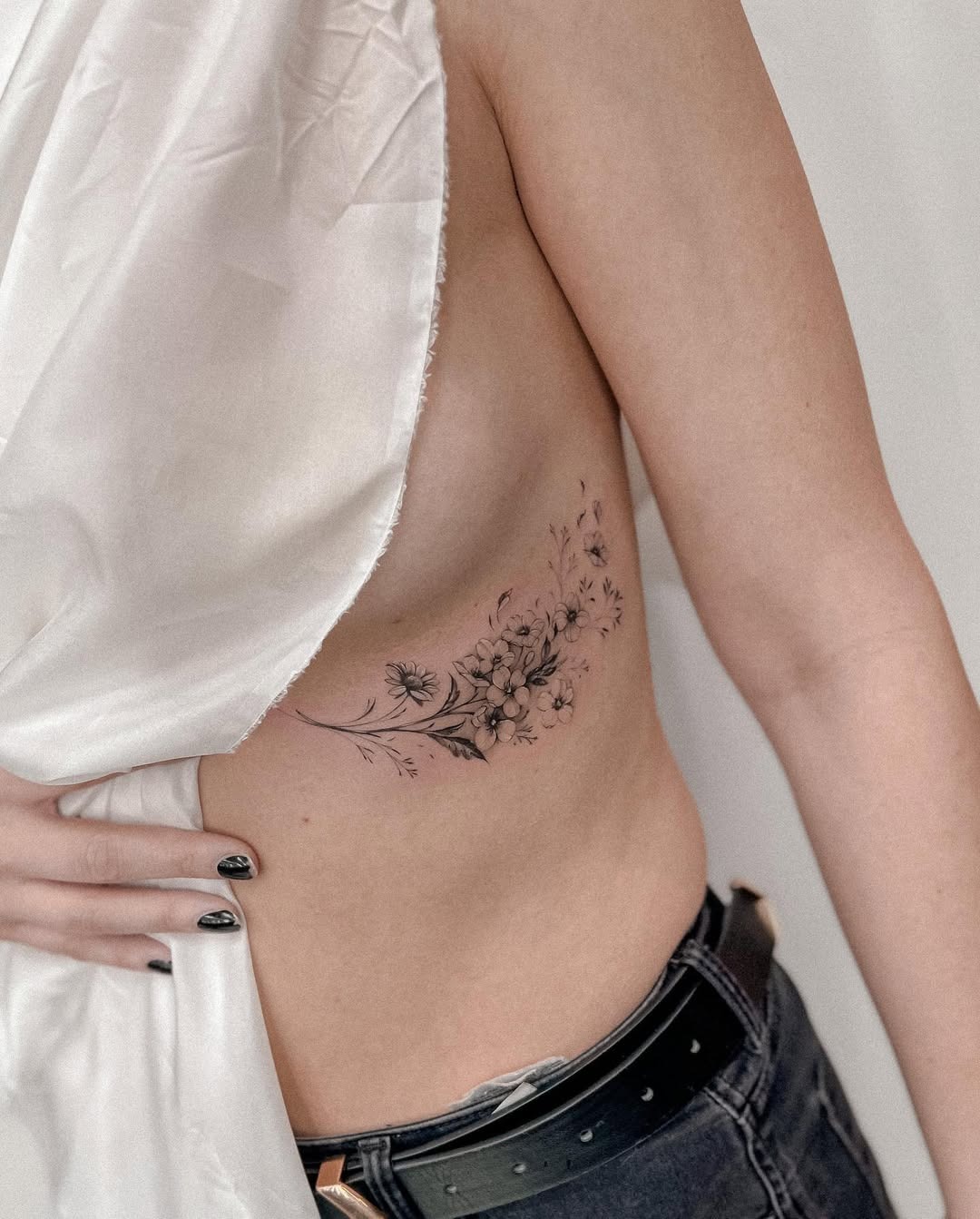 Elegant floral underboob tattoo with delicate details Tattoo Design