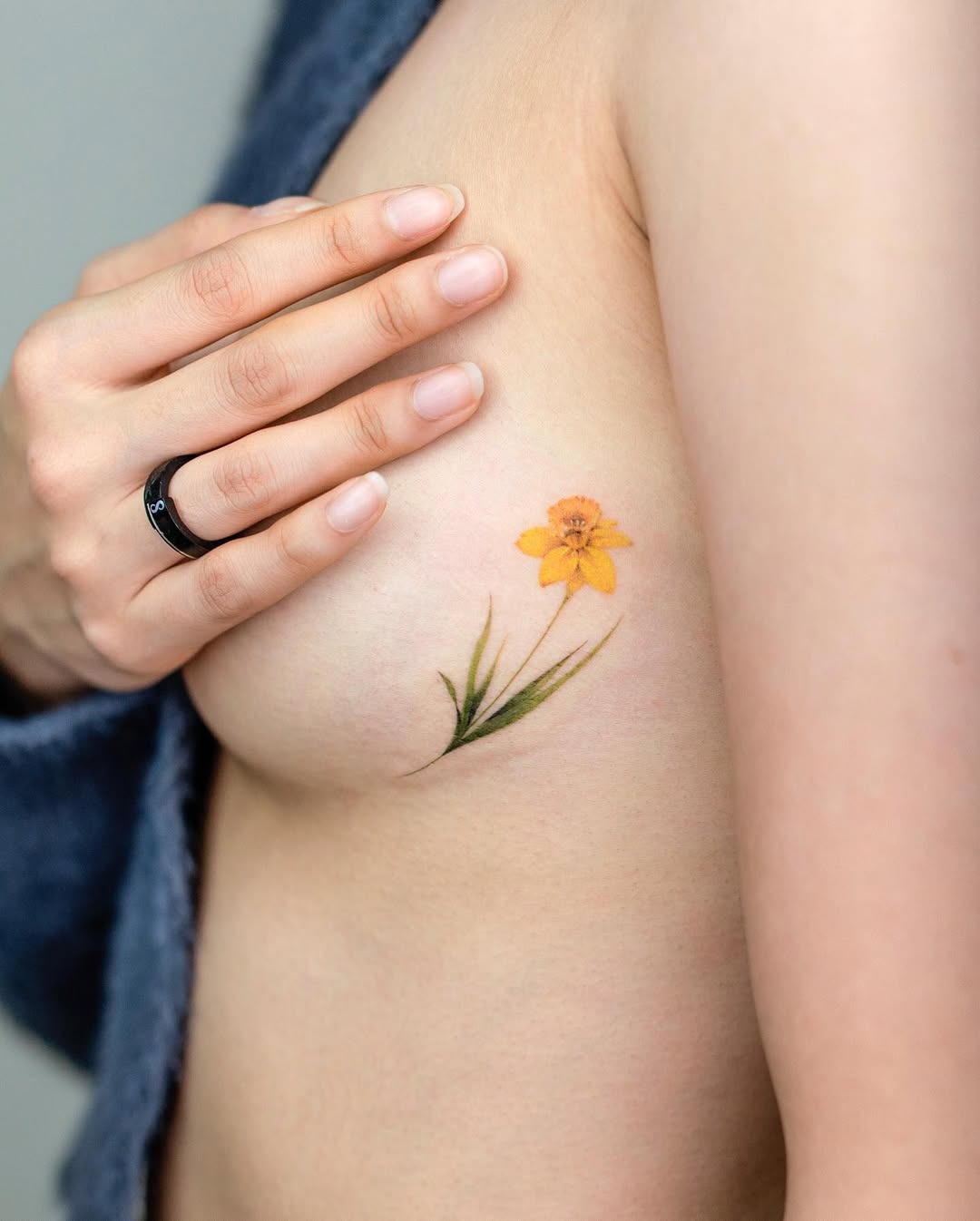 Vibrant yellow floral underboob tattoo design Tattoo Design