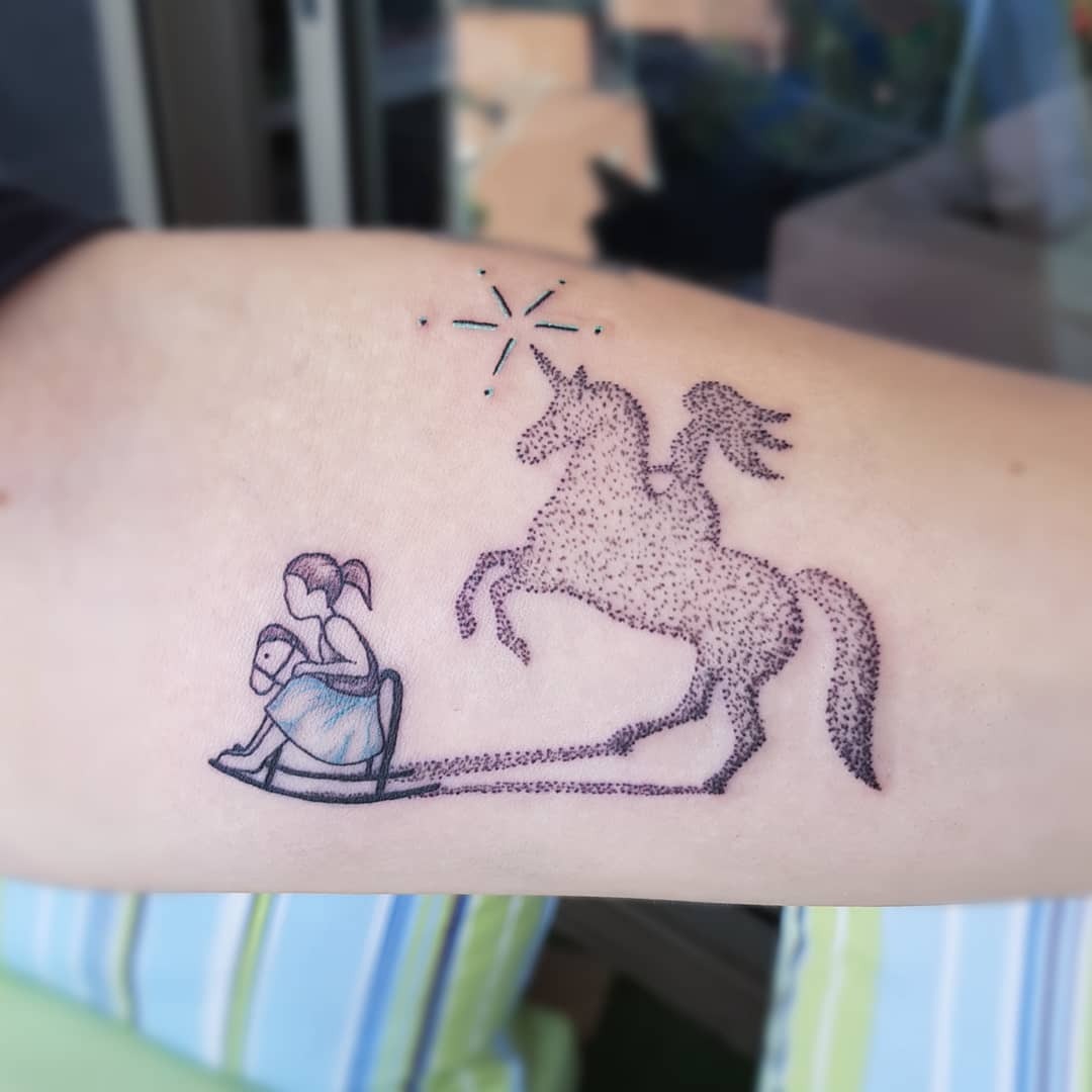 Playful unicorn tattoo with whimsical girl design Tattoo Design