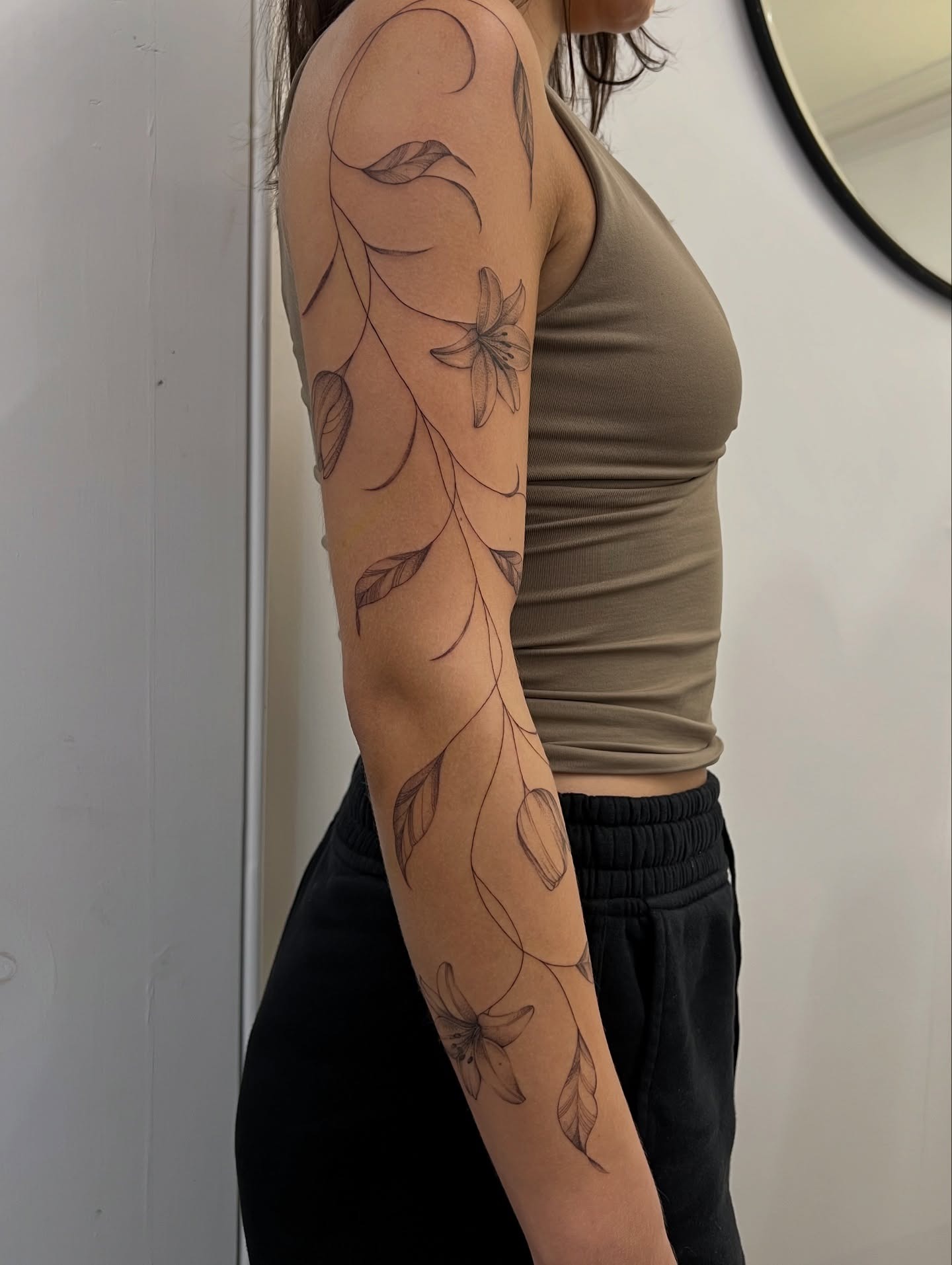 Flowing Lily Vine Tattoo on the Arm Tattoo Design