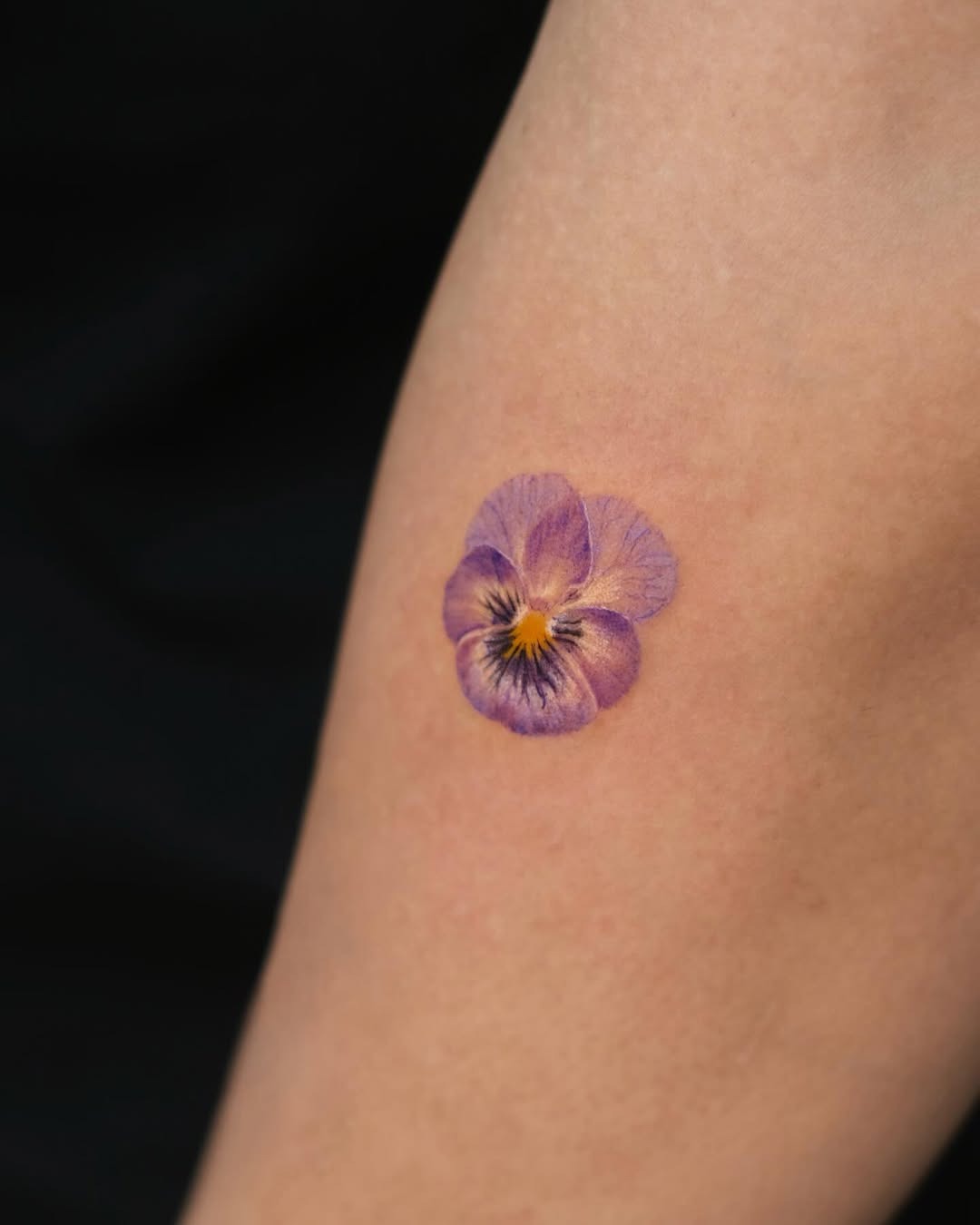 Charming violet flower tattoo on the arm Tattoo Design