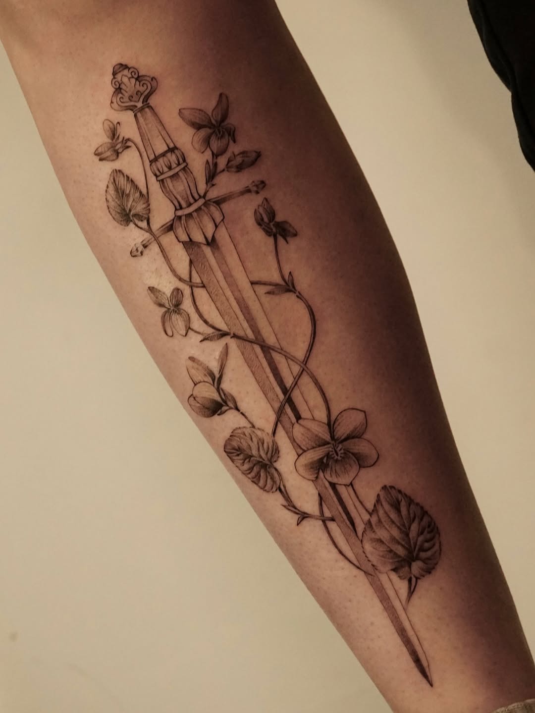 Delicate Violet Surrounding a Dagger Tattoo Tattoo Design