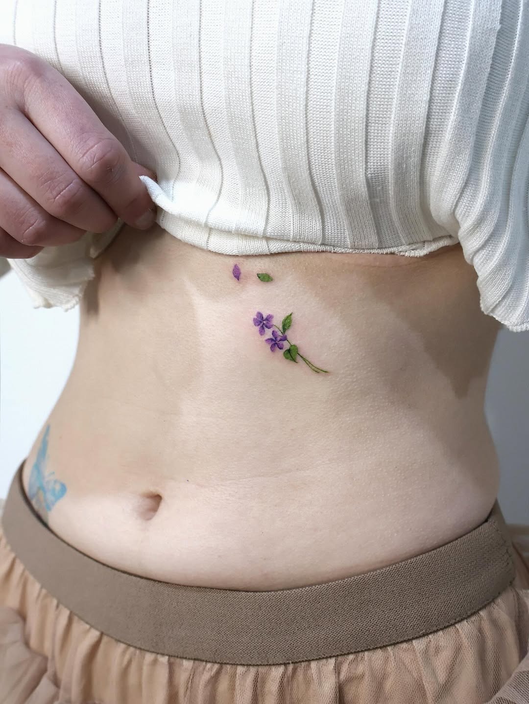 Delicate violet tattoo on the lower abdomen Tattoo Design
