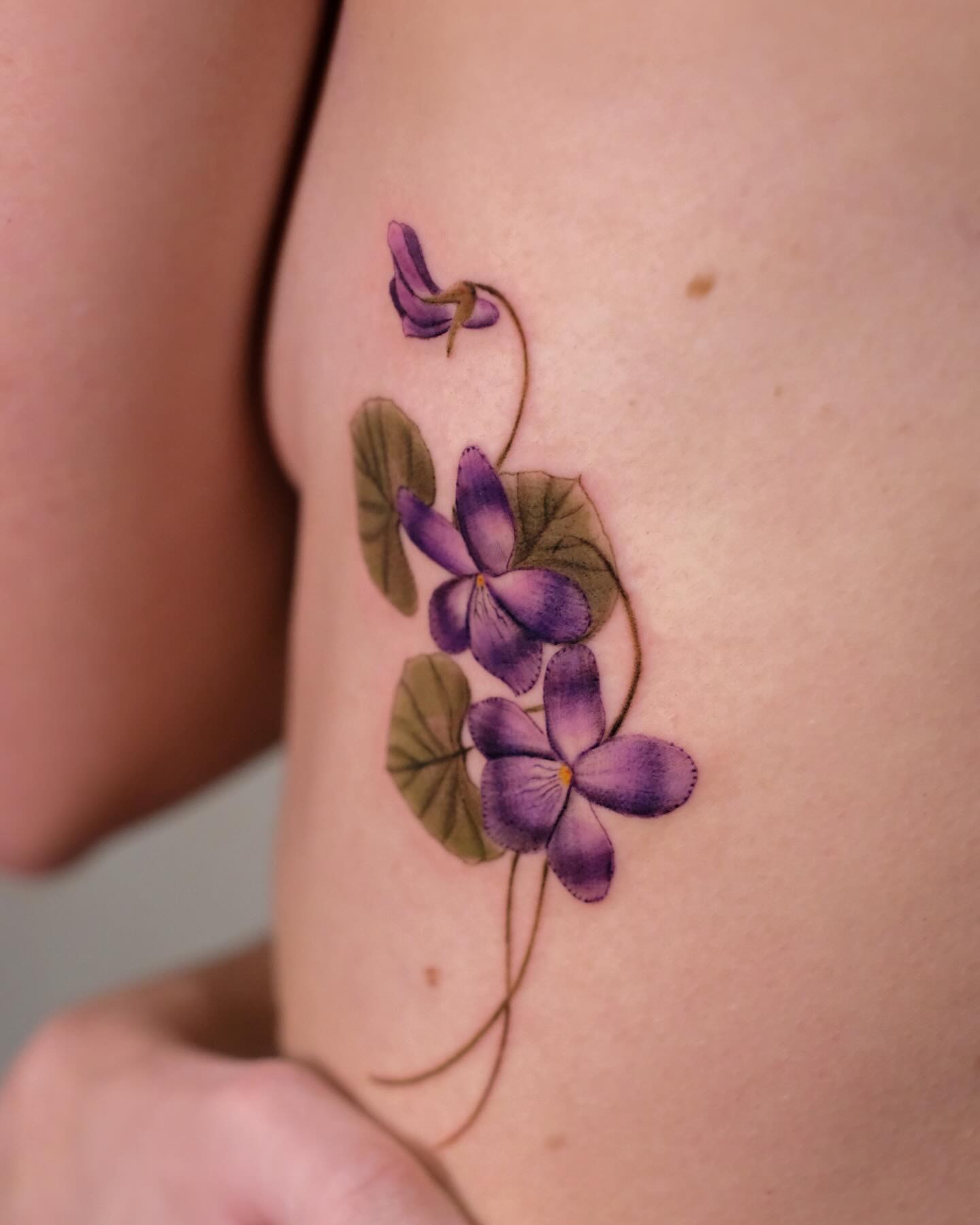 Elegant violet floral tattoo on the skin Tattoo Design