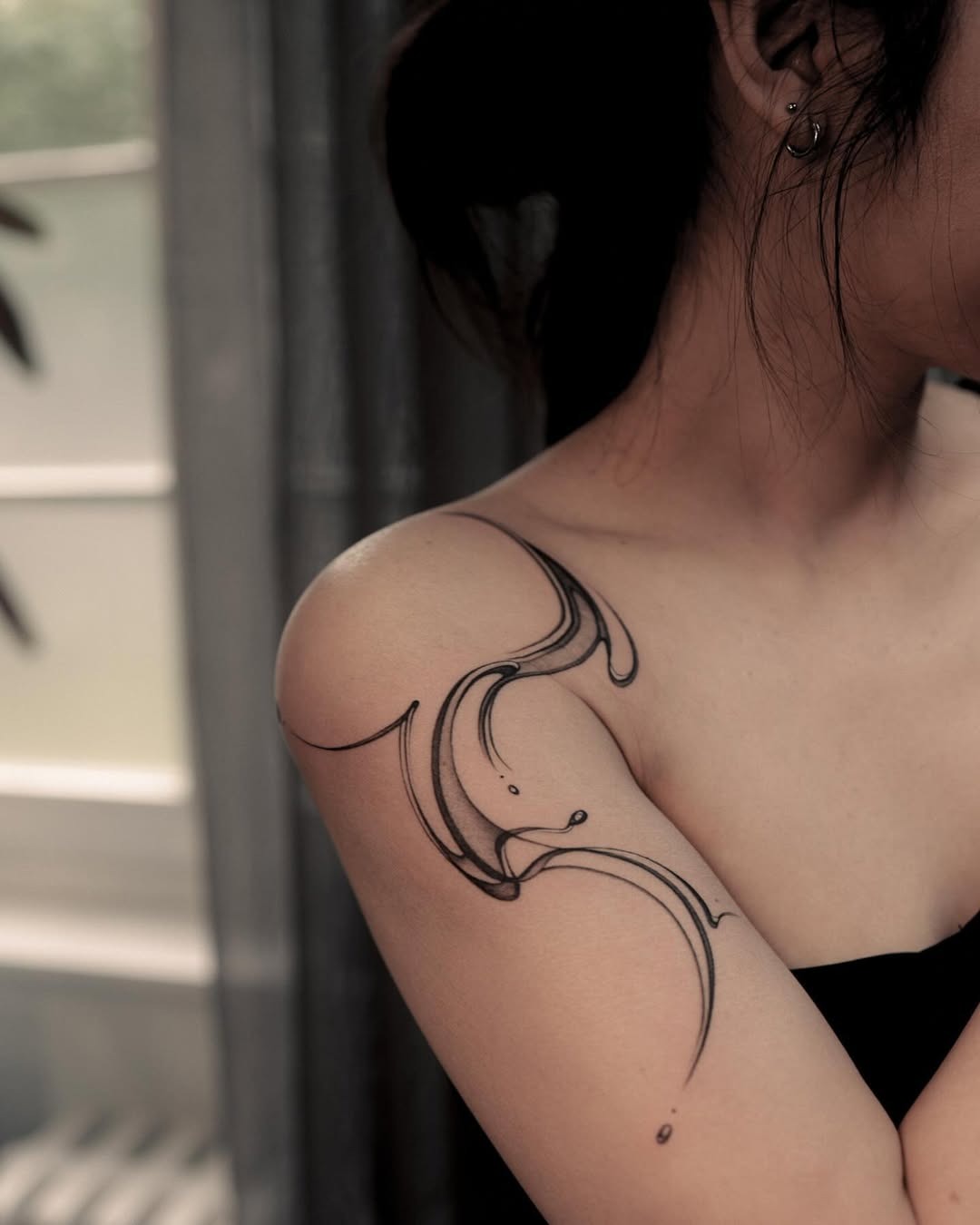 Fluid water-inspired tattoo design on shoulder Tattoo Design
