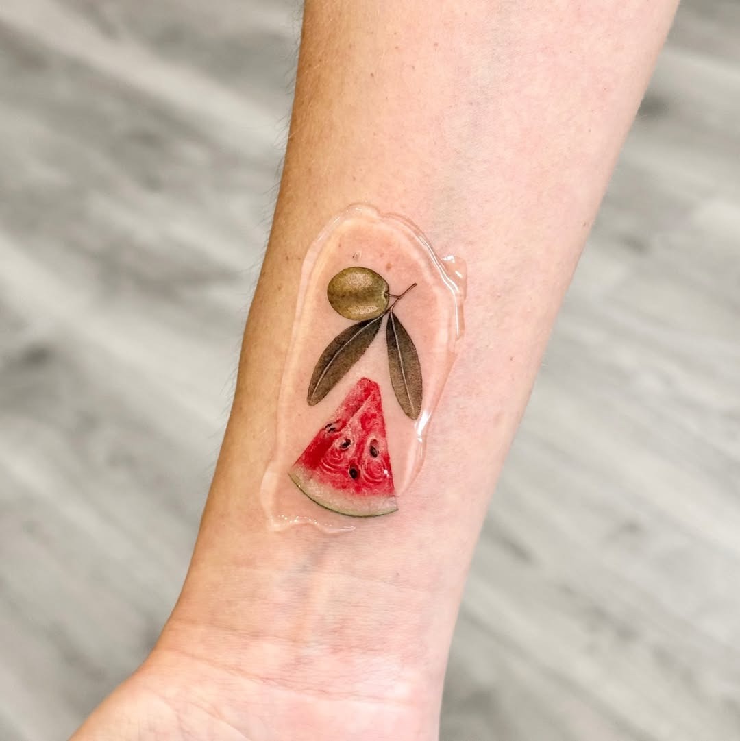 Vibrant watermelon slice with olive branch design Tattoo Design