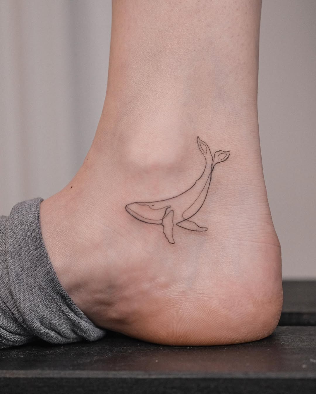 Charming Minimalist Whale Tattoo on the Ankle Tattoo Design