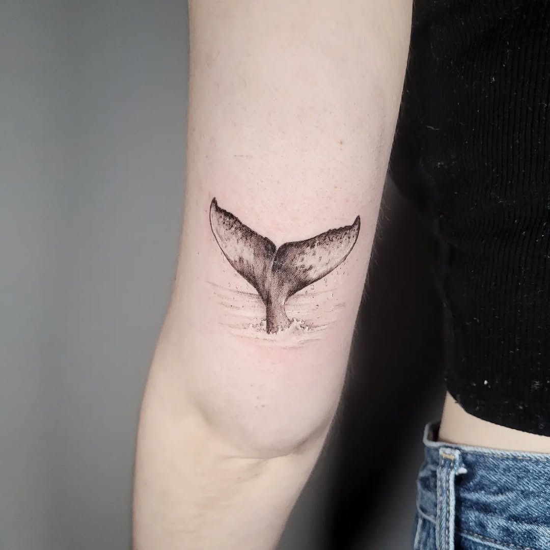 minimalist whale tail tattoo on arm Tattoo Design