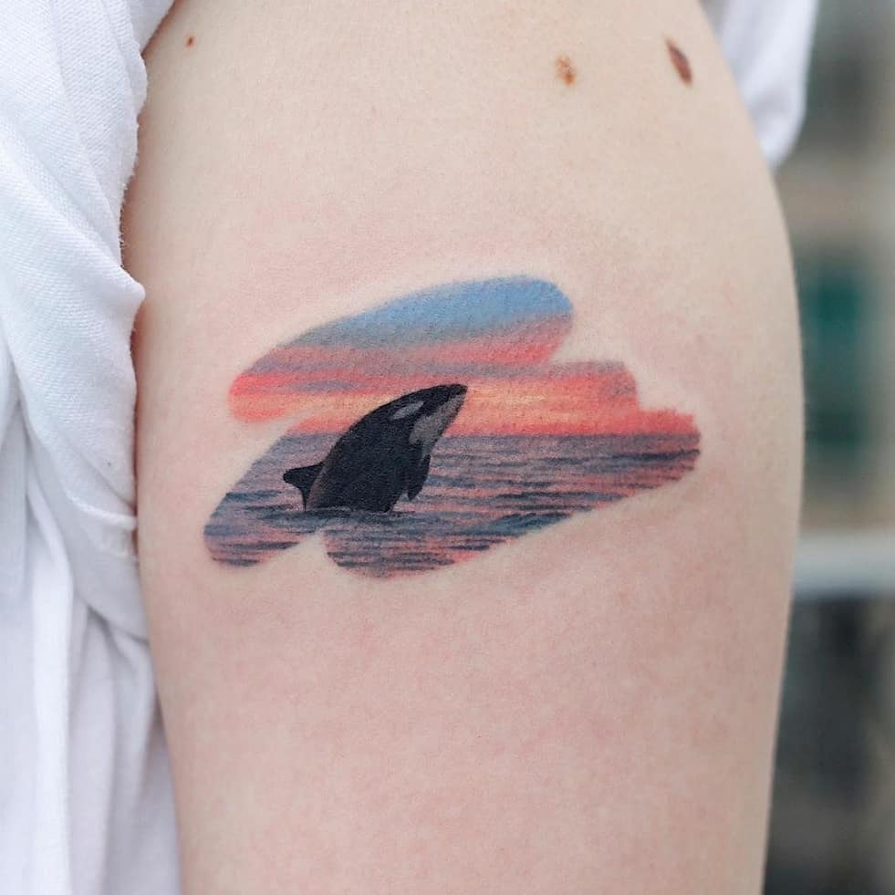 Orca emerging from a vibrant sunset swirl Tattoo Design
