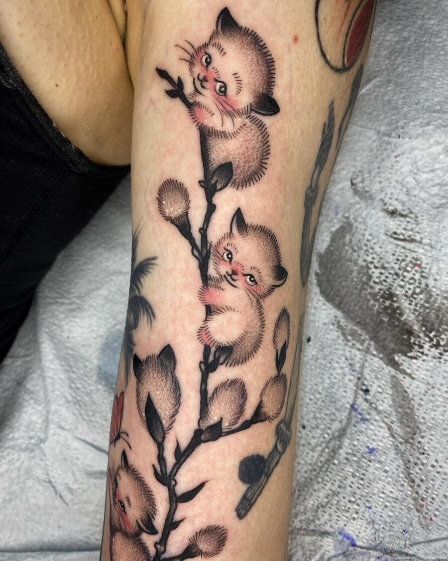 Adorable kittens playfully perched on branches Tattoo Design