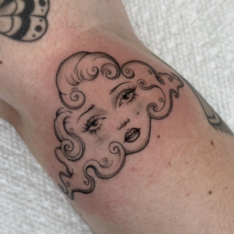Charming whimsical face tattoo with curly hair Tattoo Design
