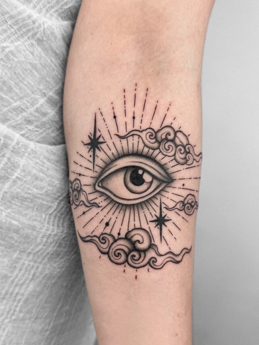 Whimsical Eye Tattoo Surrounded by Cosmic Elements Tattoo Design