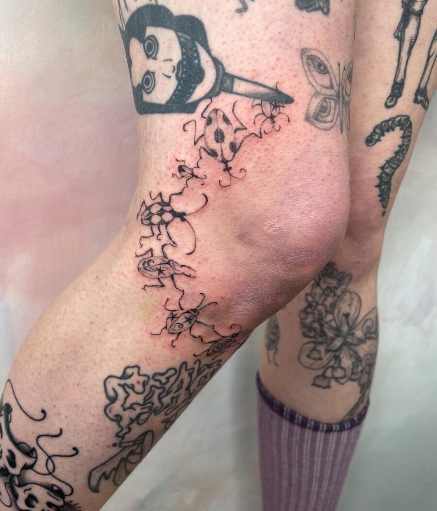 Whimsical knee tattoos with floral elements Tattoo Design