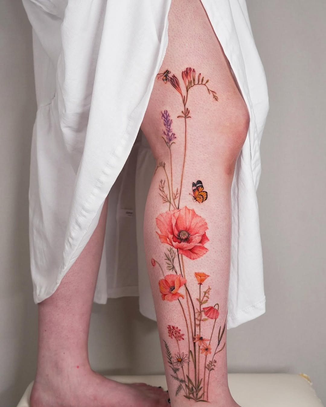 Colorful wildflower tattoo on a leg Tattoo Design