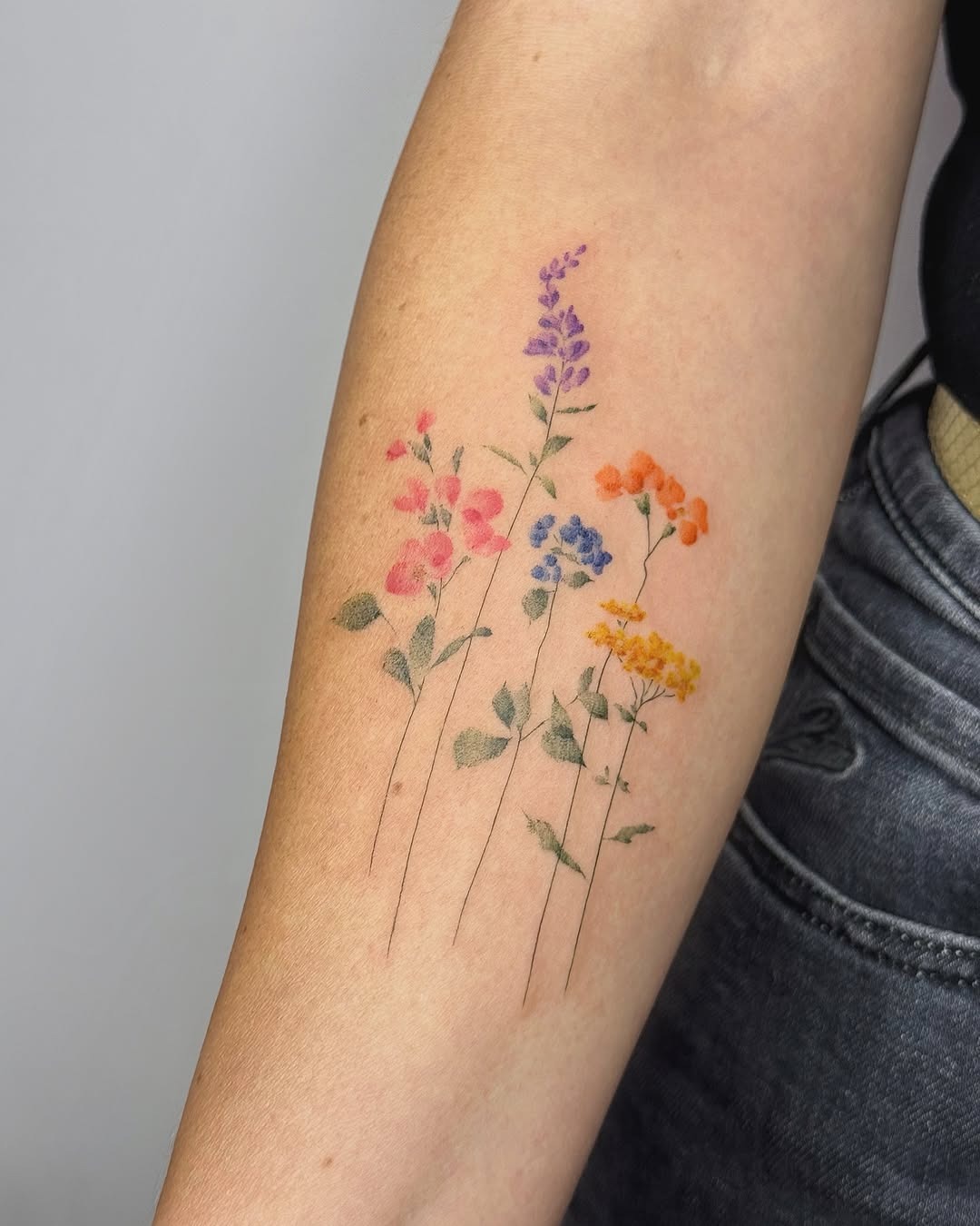 Delicate wildflower tattoo bursting with color Tattoo Design