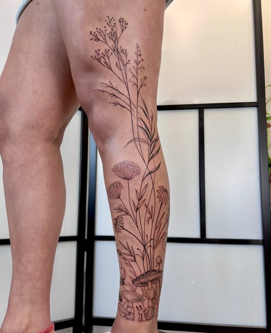 Elegant wildflower tattoo stretching along the leg Tattoo Design
