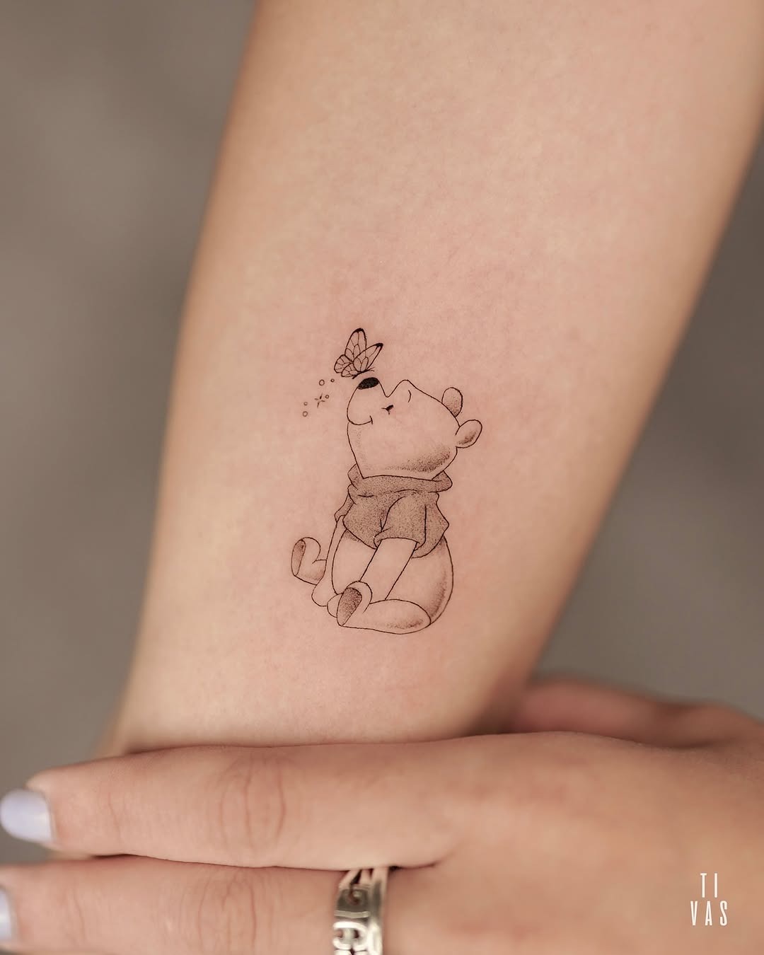 Charming Pooh Under a Butterfly’s Spell Tattoo Design