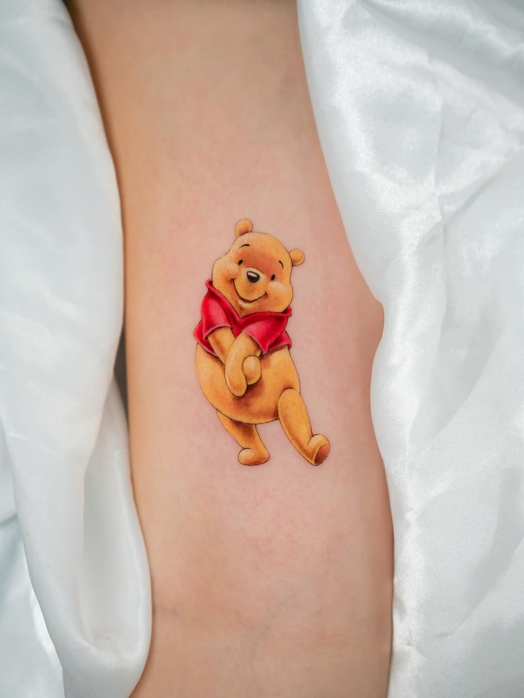 Playful Winnie the Pooh Tattoo on Skin Tattoo Design