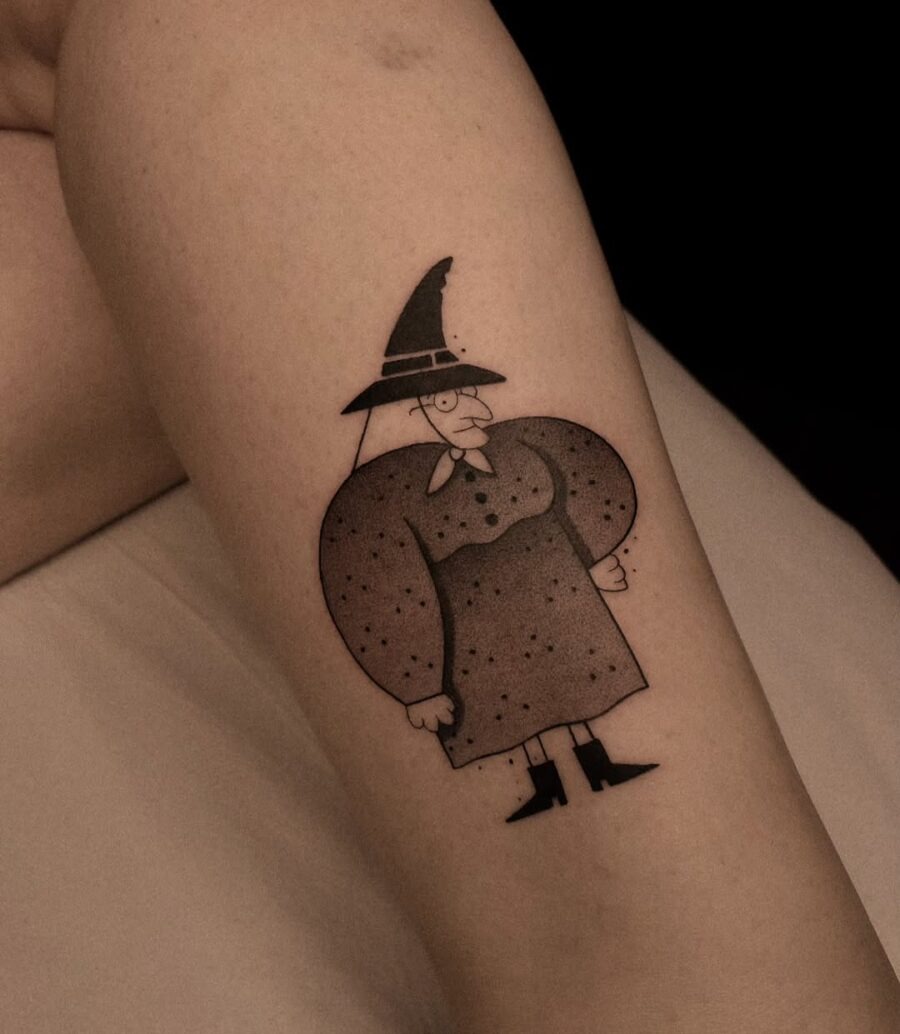 Playful cartoon witch hat tattoo on arm Tattoo Design