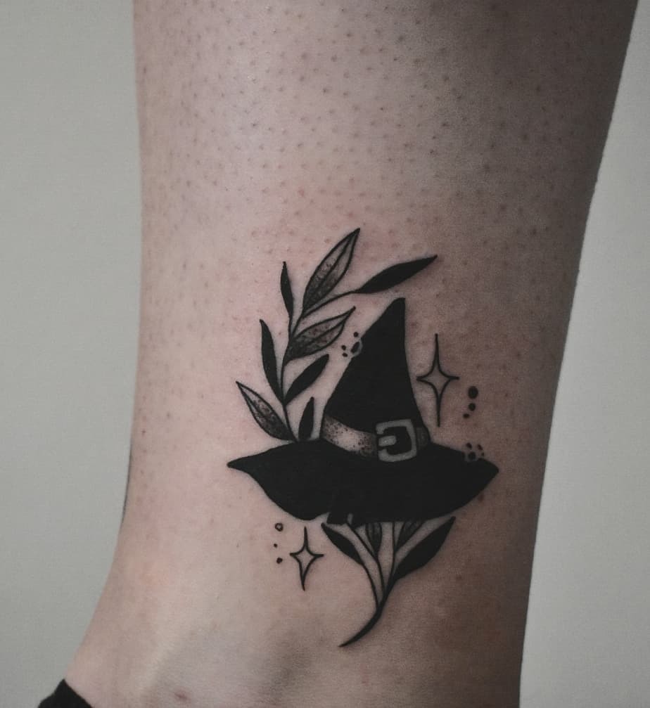 Stylish witch hat tattoo with floral elements Tattoo Design