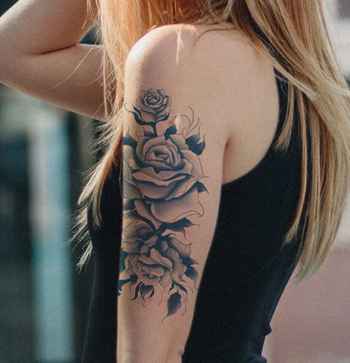 This dramatic tattoo showcases a unique blend of black and blue tones, creating a bold visual statement on the upper arm.