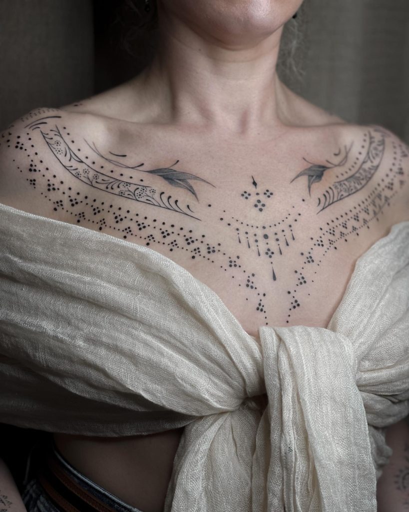This intricate dotwork tattoo spans the chest, combining geometric shapes and natural curves to create a unique ornamental piece.