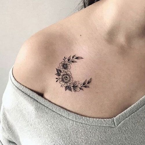 This small yet charming tattoo sits delicately on the collarbone, featuring a crescent shape filled with tiny flowers and leaves.