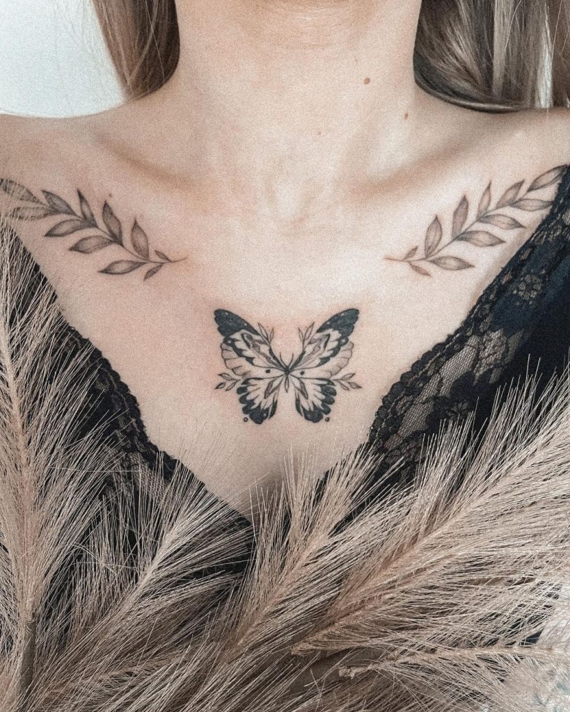 This tattoo blends the beauty of nature with a touch of symbolism, featuring a butterfly at the center, flanked by delicate laurel leaves on each side.