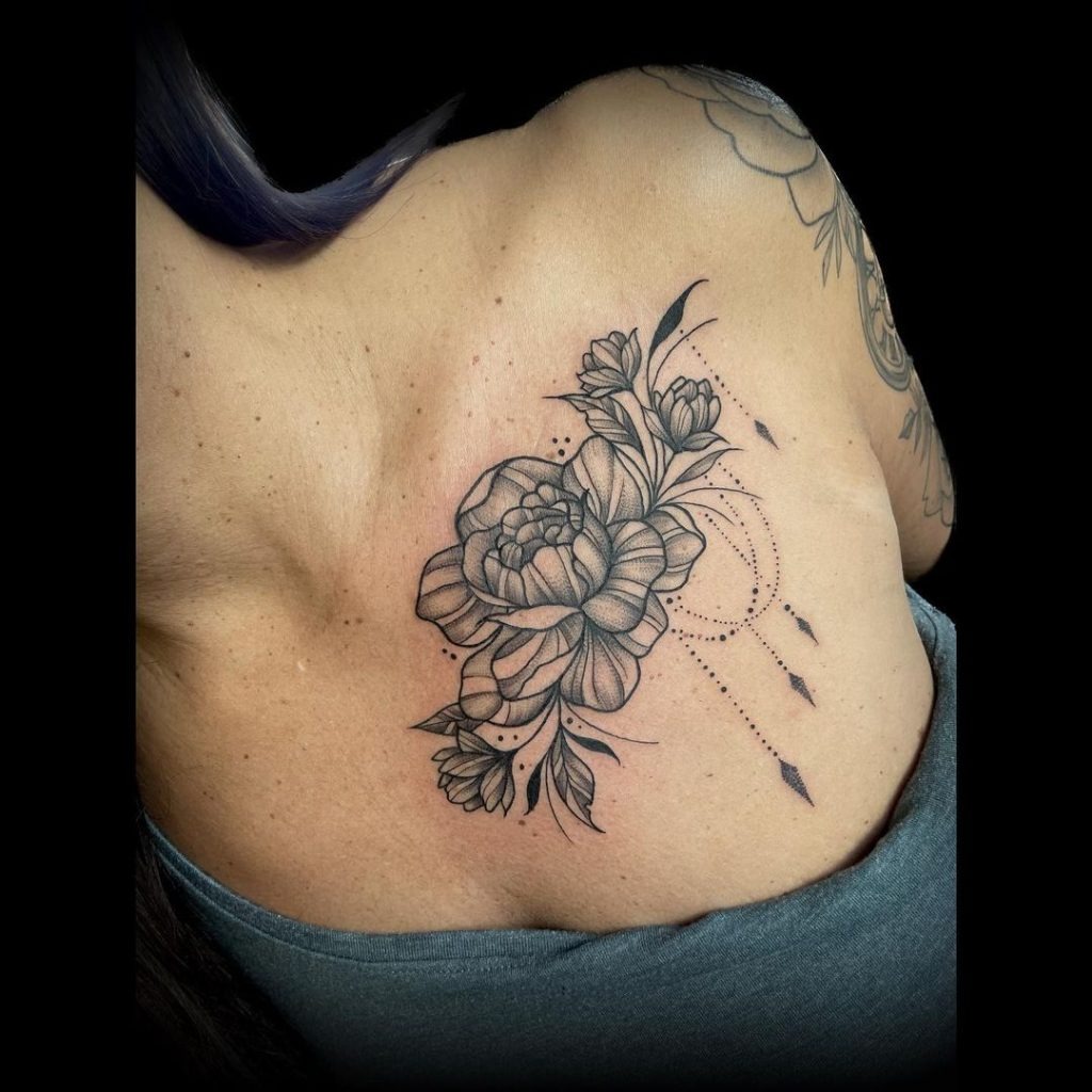 A beautiful floral tattoo positioned on the upper back, this piece is graceful and intricate.