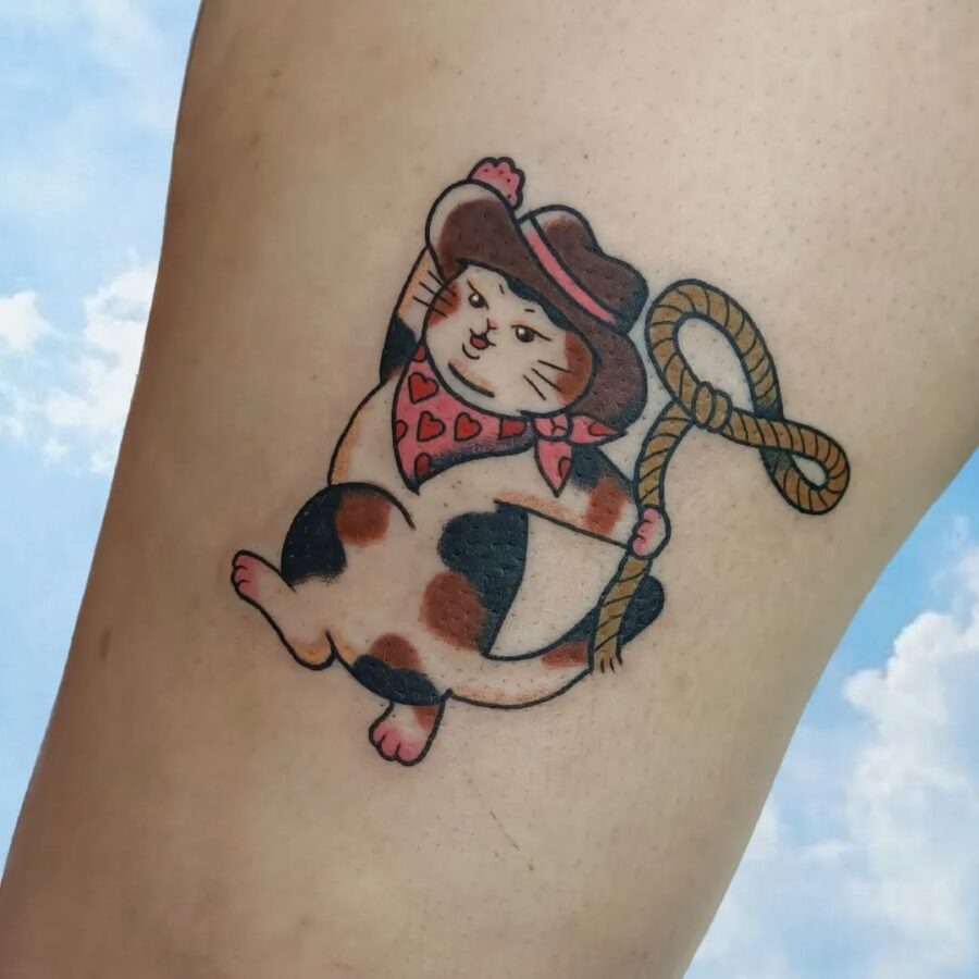 Playful cowboy cat tattoo with charm Tattoo Design