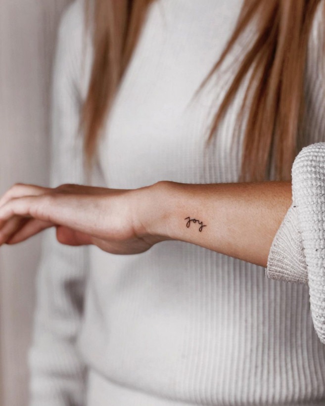 A single word can carry immense power, and this small script tattoo does just that.