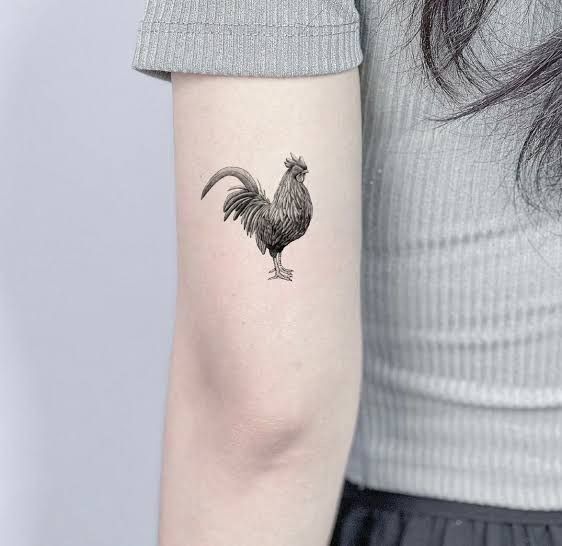 Tiny Black Rooster On The Arm Tattoo Design
