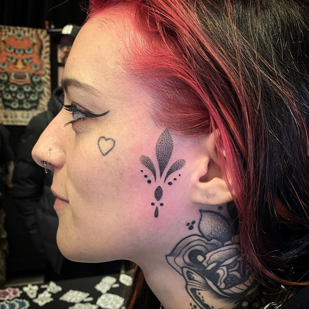 Script Tattoo “Angel” on the Cheek Tattoo Design