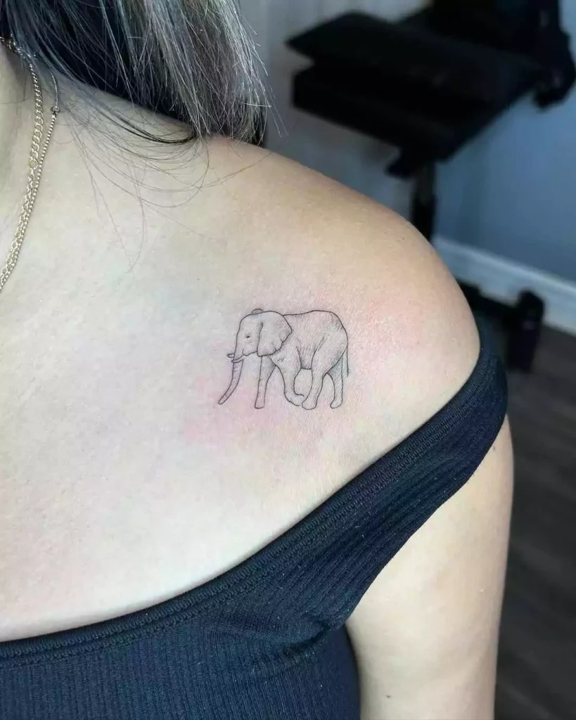 This small elephant tattoo on the shoulder offers an elegant and fine-line design, perfect for someone looking for a minimalist yet meaningful tattoo.
