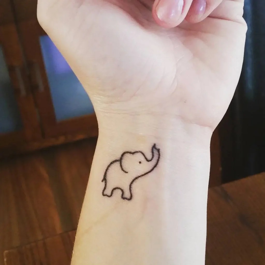 This small, cute elephant tattoo on the wrist radiates charm with its playful, rounded appearance.