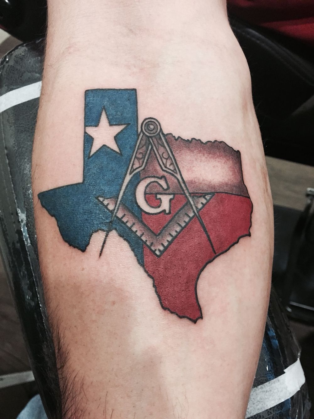 This tattoo feels like layered identity, Texas pride up front, with a deeper symbol tucked right into the center like a personal code.